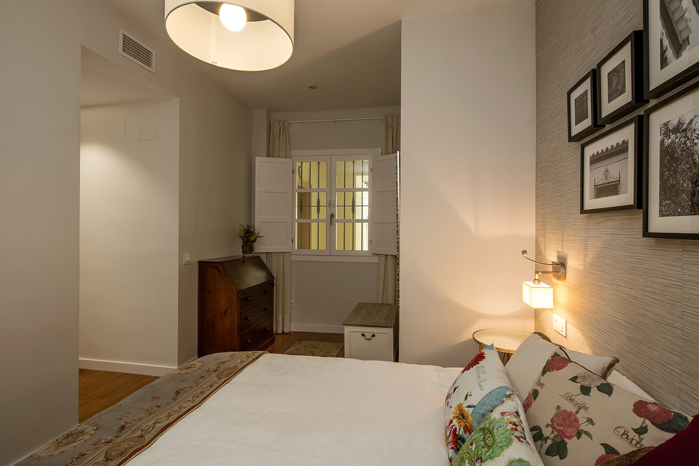 Modelo de dormitorio principal minimalista de tamaño medio con paredes grises y suelo de madera en tonos medios