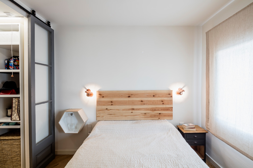 Esempio di una camera da letto scandinava con pareti bianche e pavimento in legno massello medio