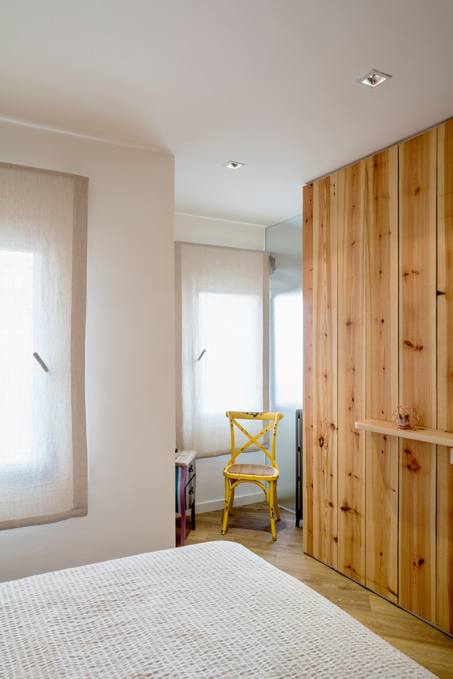 Exemple d'une chambre scandinave avec un mur blanc et un sol en bois brun.