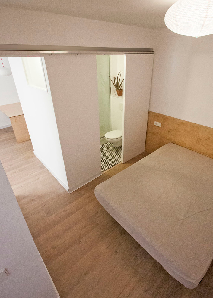 Aménagement d'une petite chambre parentale scandinave avec un mur blanc, un sol en bois brun et aucune cheminée.