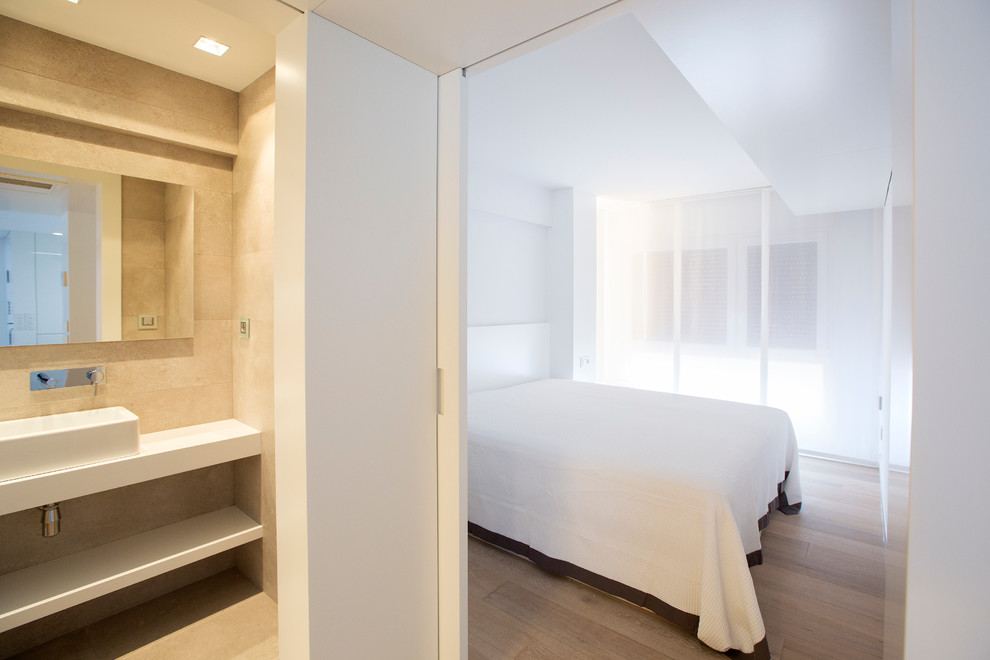 Foto de dormitorio principal minimalista de tamaño medio sin chimenea con paredes blancas y suelo de madera en tonos medios
