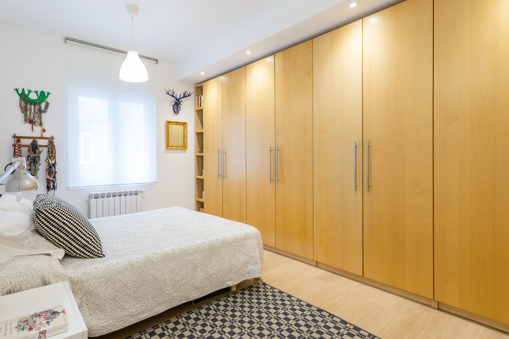Ejemplo de dormitorio principal contemporáneo con paredes blancas, suelo de madera clara y suelo beige
