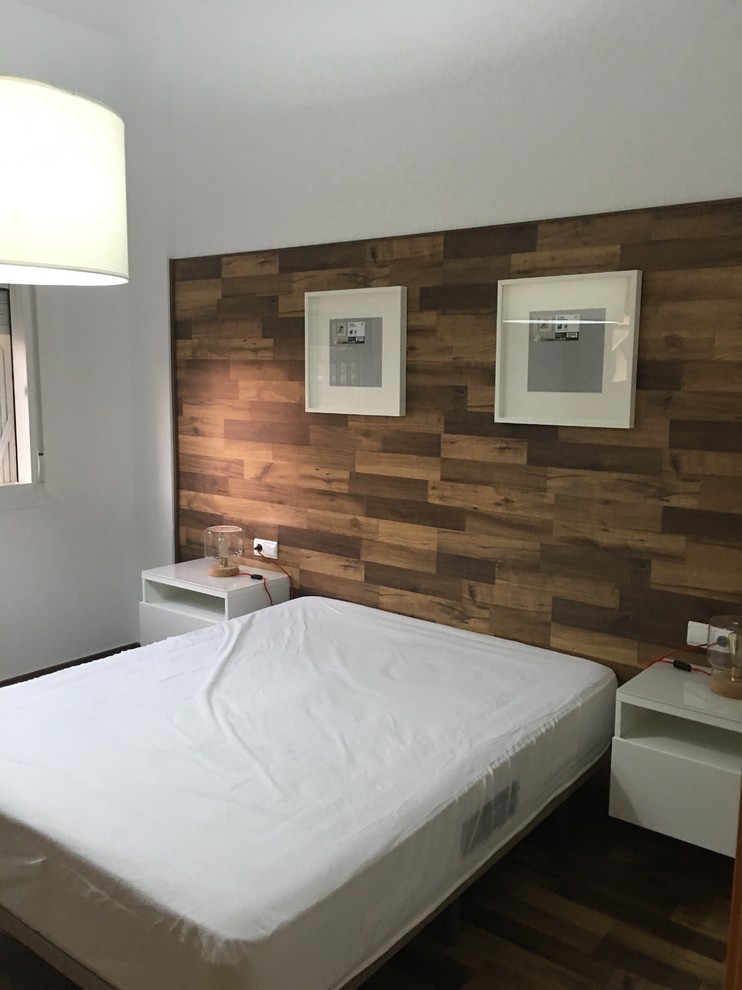 Modelo de dormitorio principal nórdico grande sin chimenea con paredes blancas, suelo de madera en tonos medios y suelo marrón