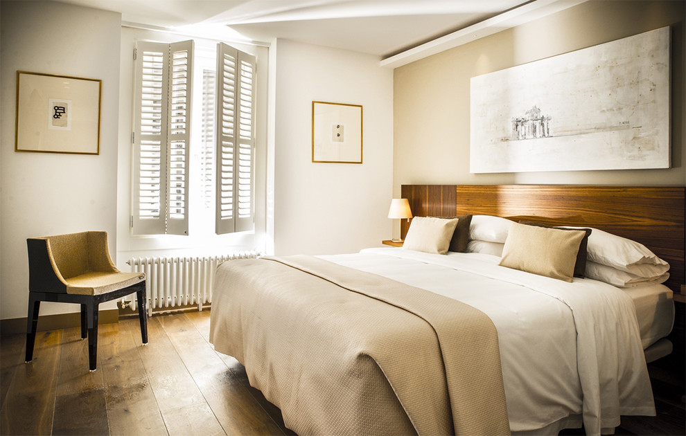 Großes Klassisches Hauptschlafzimmer mit weißer Wandfarbe, braunem Holzboden und braunem Boden in Madrid