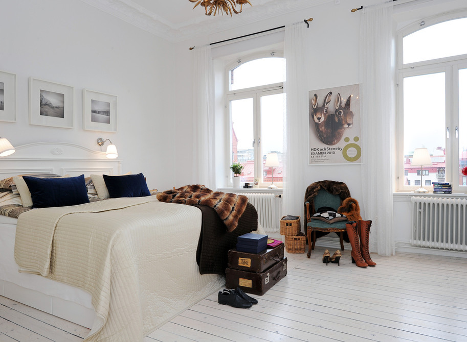 Modelo de dormitorio principal clásico renovado de tamaño medio sin chimenea con paredes blancas y suelo de madera pintada
