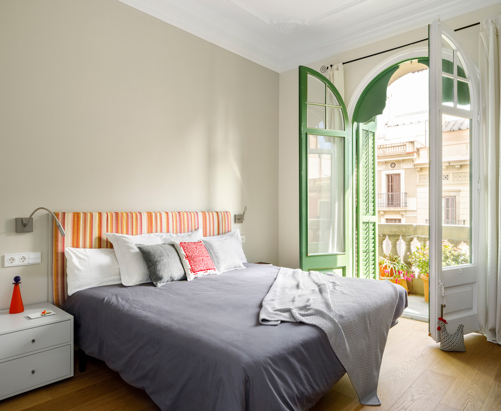 Foto de dormitorio principal actual con paredes beige, suelo de madera en tonos medios y suelo marrón