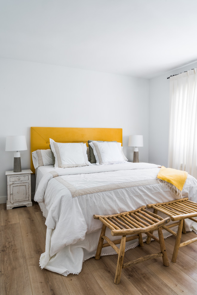 Ejemplo de dormitorio escandinavo con paredes blancas, suelo de madera en tonos medios y suelo marrón