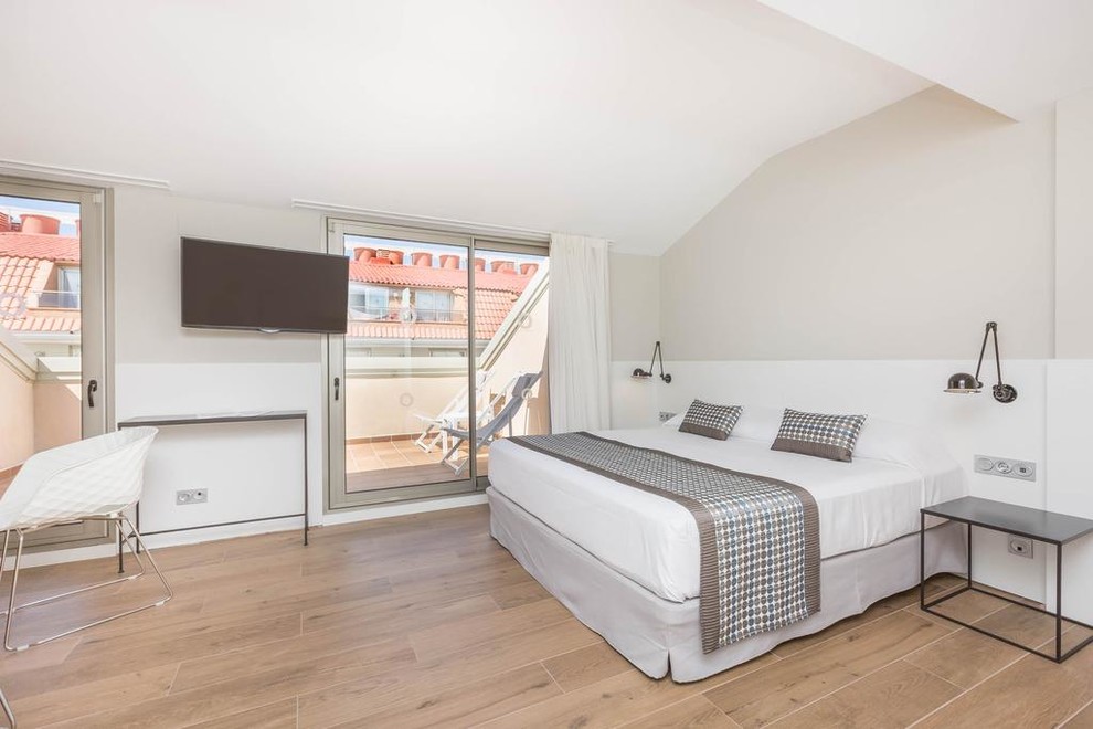 Mittelgroßes Skandinavisches Hauptschlafzimmer mit weißer Wandfarbe, braunem Holzboden und braunem Boden in Sonstige
