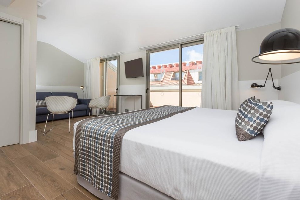 Kleines Nordisches Hauptschlafzimmer mit weißer Wandfarbe, braunem Holzboden und braunem Boden in Sonstige