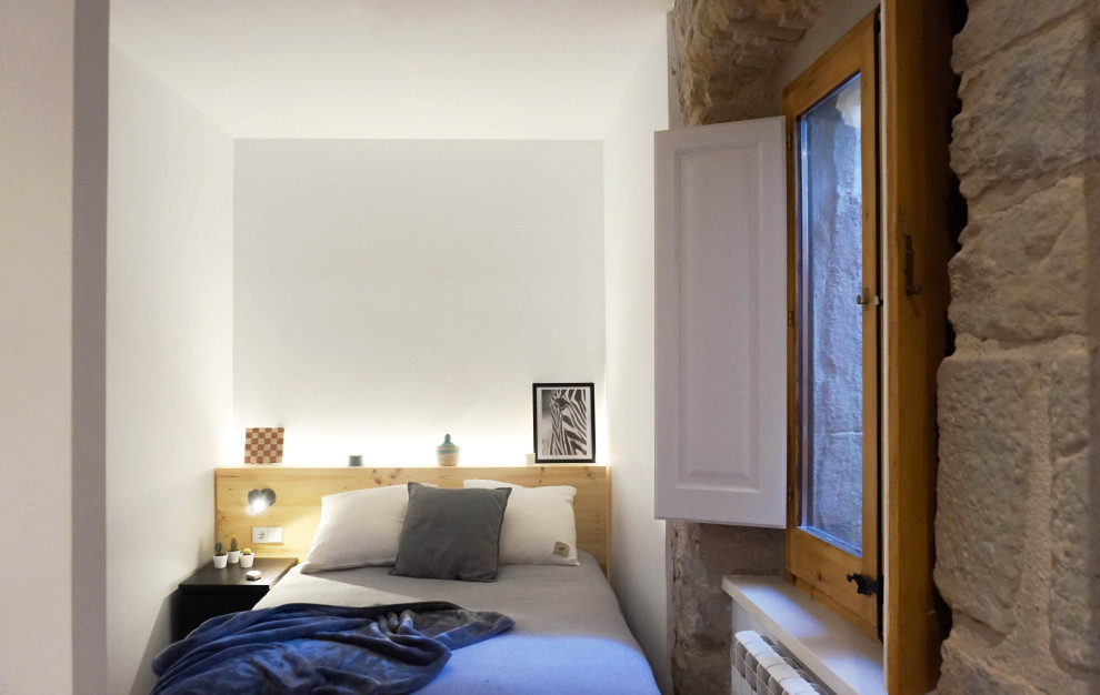 Idée de décoration pour une grande chambre parentale minimaliste avec un mur blanc, tomettes au sol et un sol marron.