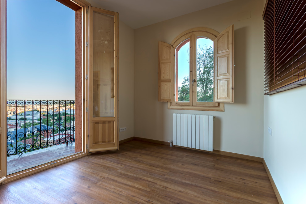 Mittelgroßes Mediterranes Hauptschlafzimmer ohne Kamin mit beiger Wandfarbe, braunem Holzboden und braunem Boden in Barcelona