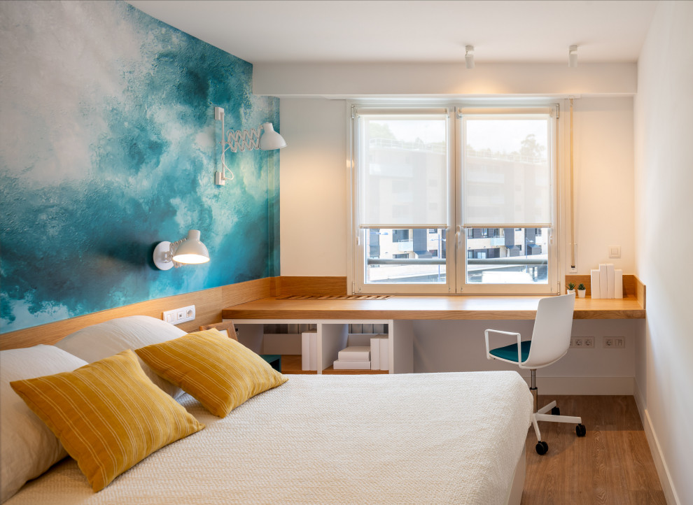 На фото: большая гостевая спальня (комната для гостей) в стиле неоклассика (современная классика) с синими стенами, полом из ламината, коричневым полом и обоями на стенах без камина с
