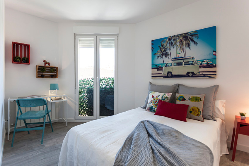 Imagen de habitación de invitados actual de tamaño medio con paredes blancas, suelo laminado y suelo gris