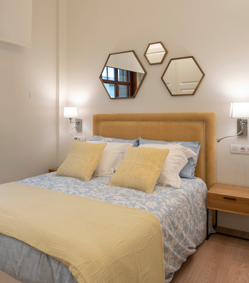 Идея дизайна: спальня среднего размера в современном стиле с белыми стенами, полом из ламината и коричневым полом без камина