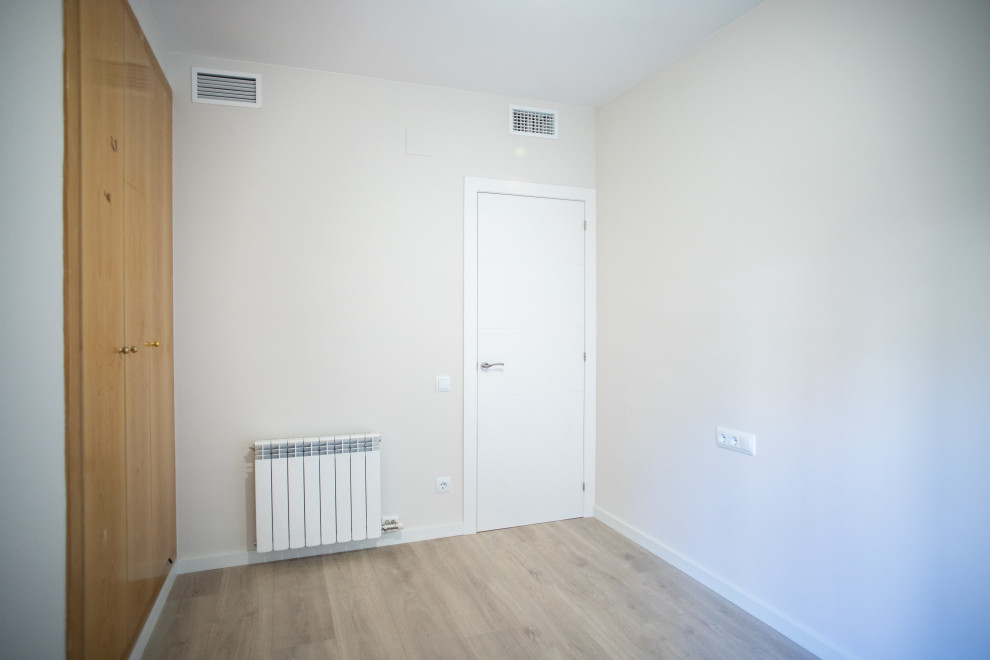 Ejemplo de habitación de invitados actual de tamaño medio sin chimenea con paredes beige, suelo de baldosas de cerámica y suelo marrón