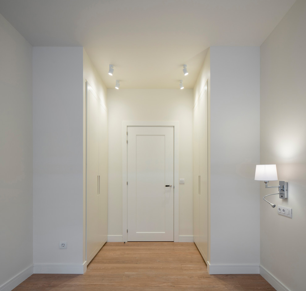 Imagen de habitación de invitados clásica renovada de tamaño medio sin chimenea con suelo laminado, suelo marrón y paredes beige