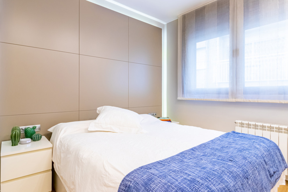 Diseño de dormitorio principal actual pequeño con paredes beige y suelo laminado