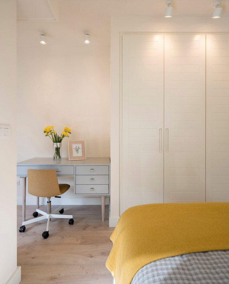 Modelo de habitación de invitados tradicional renovada de tamaño medio sin chimenea con paredes beige, suelo laminado y suelo beige