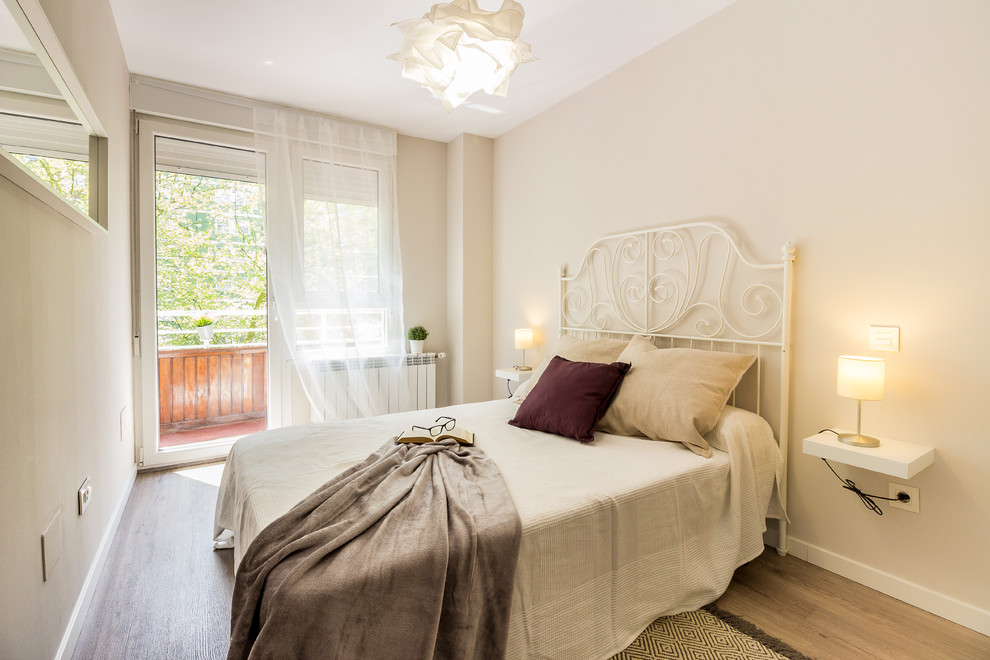 Foto de habitación de invitados actual pequeña con suelo laminado, paredes beige y suelo beige