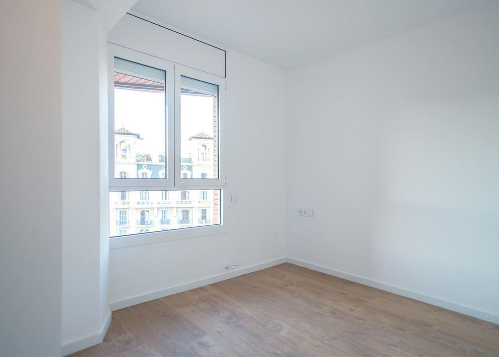 Mittelgroßes Modernes Hauptschlafzimmer ohne Kamin mit weißer Wandfarbe, braunem Holzboden und braunem Boden in Barcelona