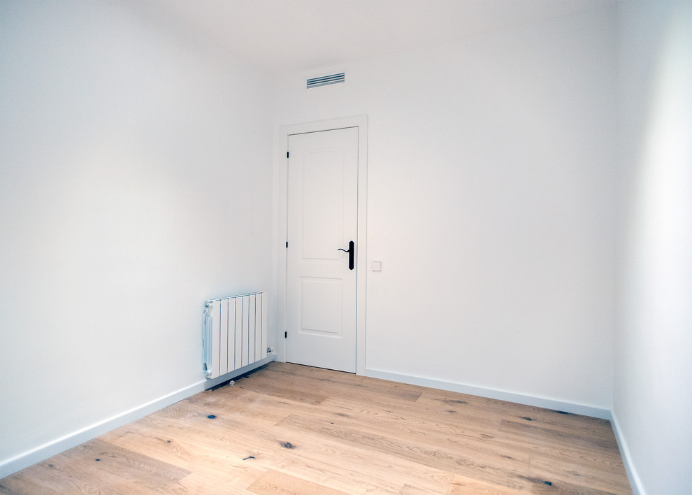 Inspiration pour une chambre d'amis minimaliste de taille moyenne avec un mur blanc, un sol en bois brun, aucune cheminée et un sol marron.