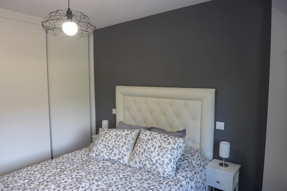 Foto de dormitorio principal moderno de tamaño medio con paredes grises, suelo laminado y suelo gris
