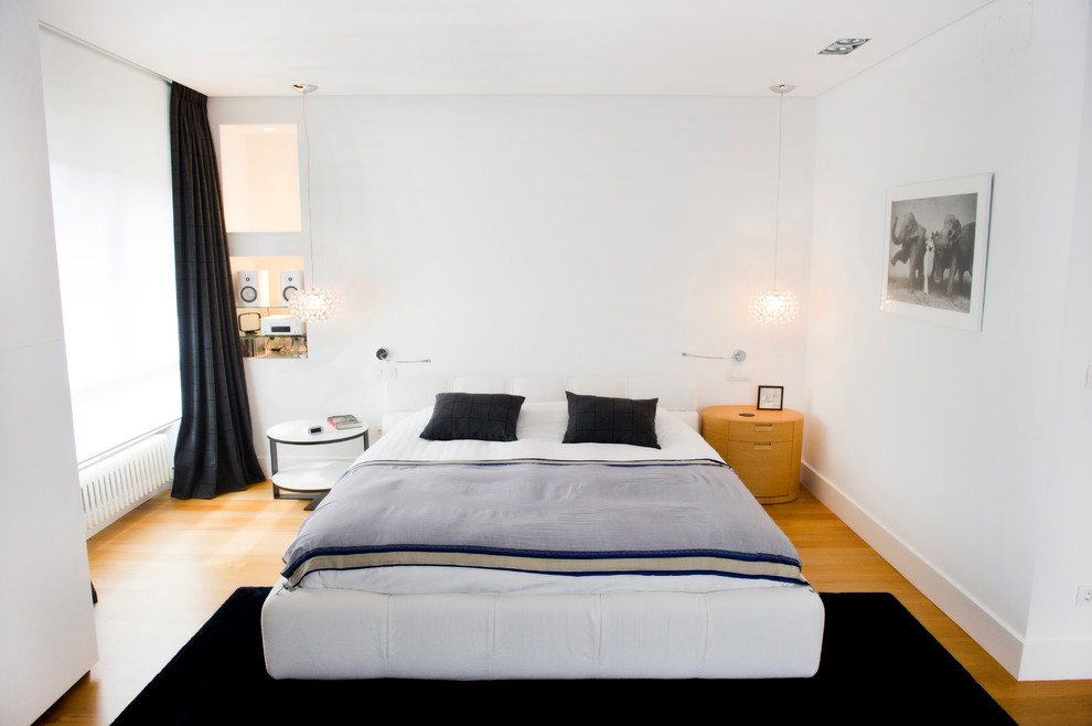 Ejemplo de dormitorio principal clásico renovado de tamaño medio sin chimenea con paredes blancas y suelo de madera en tonos medios