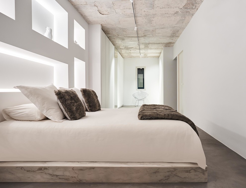 Großes Modernes Hauptschlafzimmer ohne Kamin mit weißer Wandfarbe und Betonboden in Sonstige