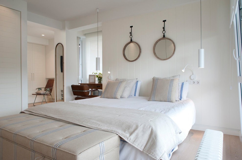 Diseño de dormitorio principal marinero grande con paredes blancas, suelo de madera en tonos medios y suelo marrón