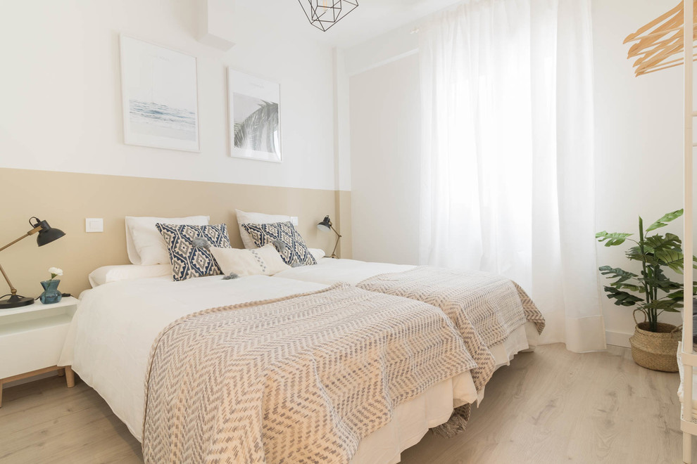 Diseño de dormitorio contemporáneo sin chimenea con paredes beige y suelo de madera clara