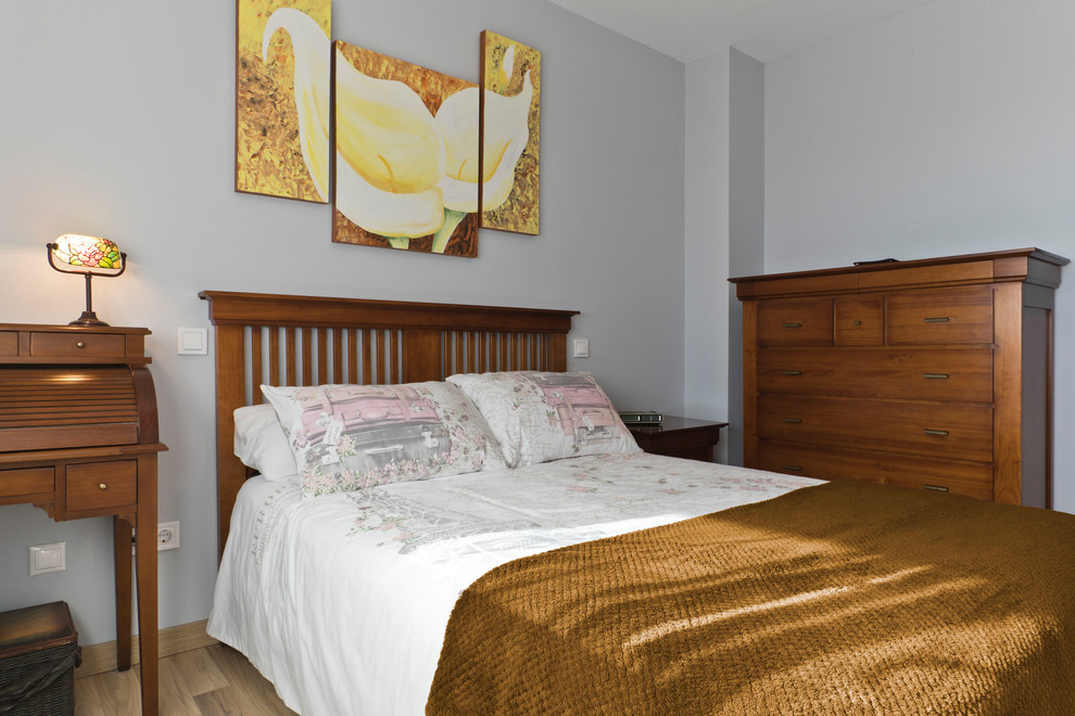 Foto de dormitorio principal tradicional de tamaño medio con paredes azules, suelo de madera clara y suelo marrón