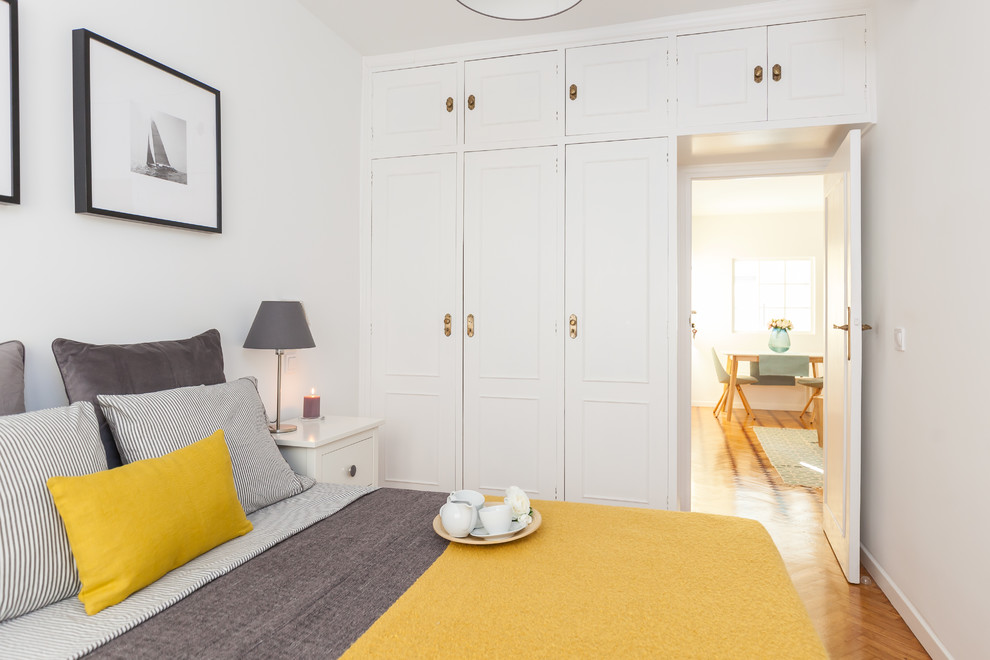 マドリードにあるトランジショナルスタイルのおしゃれな寝室 (白い壁、無垢フローリング、茶色い床)