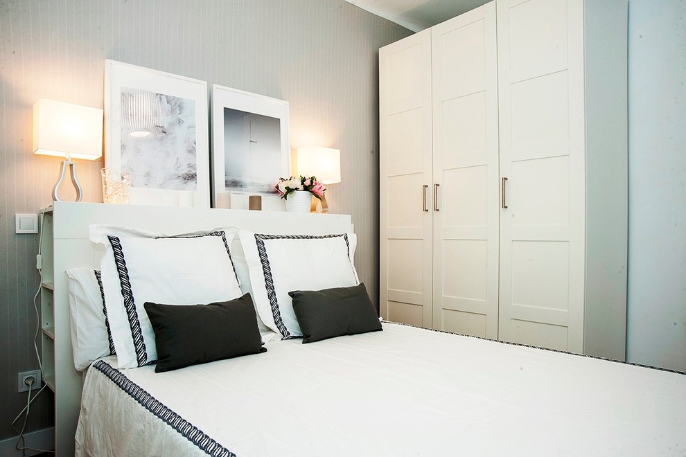 Modelo de dormitorio principal nórdico de tamaño medio con paredes grises, suelo de madera en tonos medios y suelo marrón