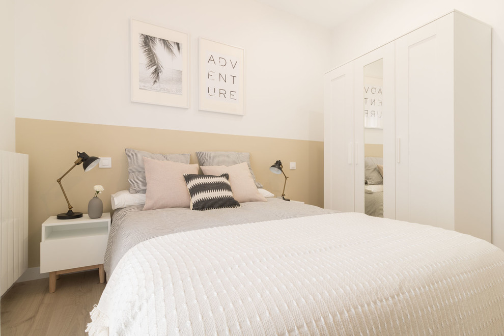 Immagine di una camera da letto scandinava con pareti beige e parquet chiaro