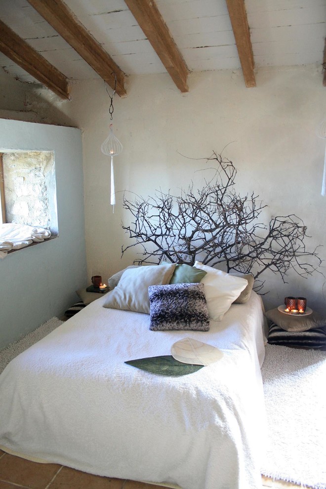 Exemple d'une petite chambre nature avec un mur beige, un sol en carrelage de porcelaine, une cheminée standard, un manteau de cheminée en brique et un sol beige.
