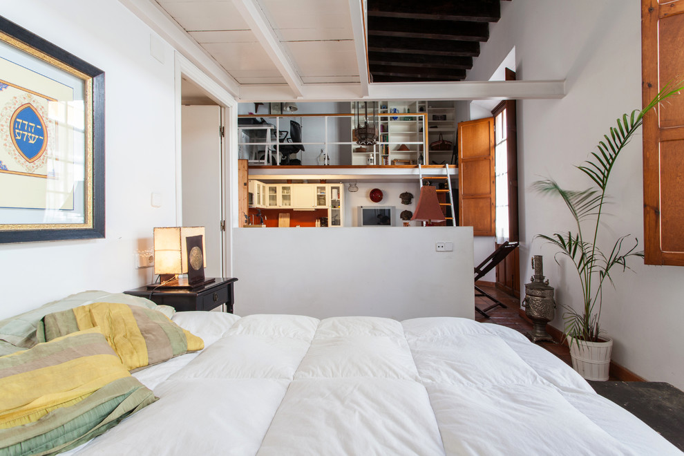 Photo of a medium sized mediterranean mezzanine bedroom in Seville with white walls, terracotta flooring and no fireplace.