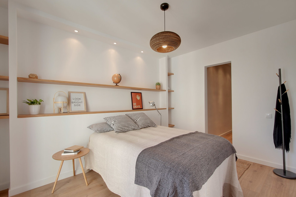 Aménagement d'une chambre parentale scandinave de taille moyenne avec un mur blanc, un sol en bois brun et aucune cheminée.