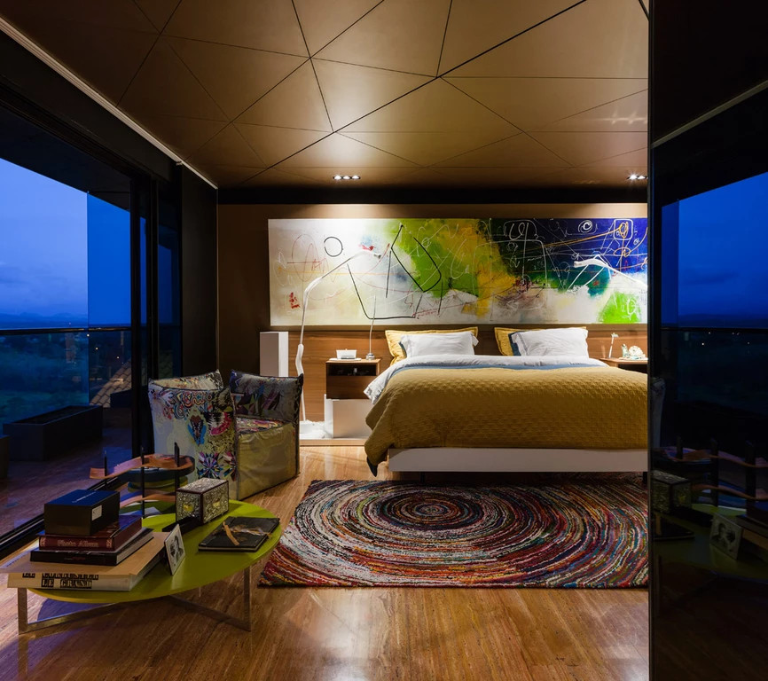На фото: большая хозяйская спальня в стиле модернизм с мраморным полом и коричневыми стенами