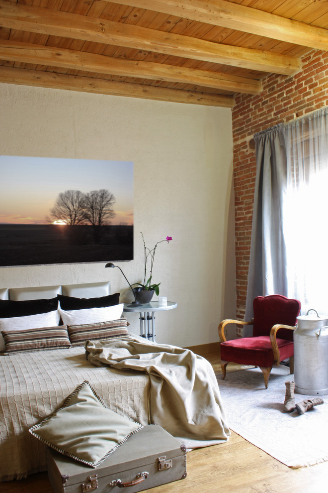 Imagen de dormitorio principal campestre grande con paredes beige y suelo de madera en tonos medios
