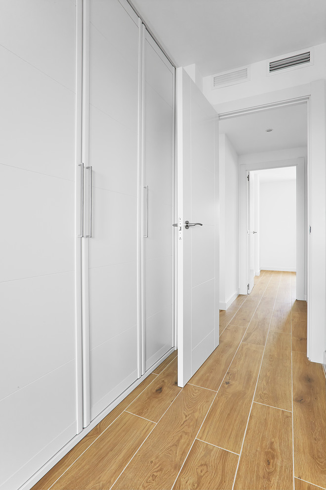 Aménagement d'une chambre parentale scandinave de taille moyenne avec un mur blanc, tomettes au sol et un sol marron.