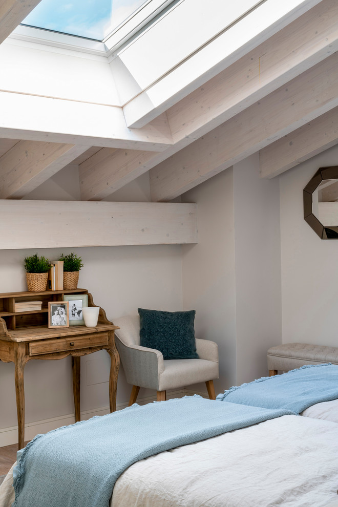 Ejemplo de habitación de invitados tradicional renovada de tamaño medio sin chimenea con paredes beige, suelo laminado y suelo marrón