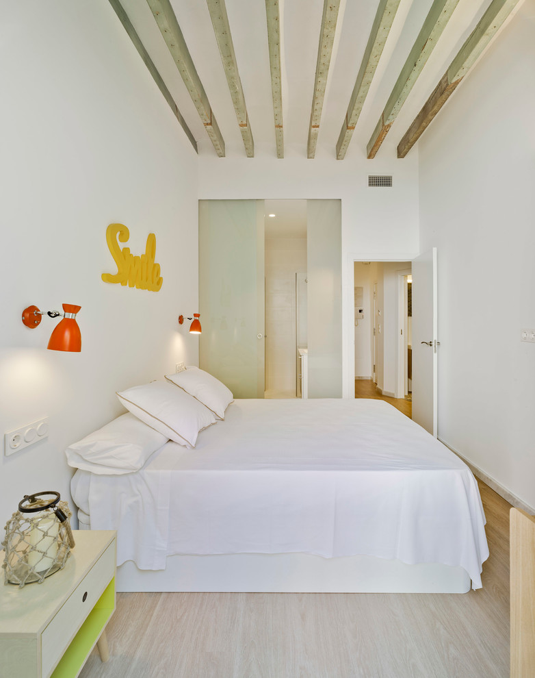 Modelo de dormitorio principal mediterráneo pequeño con paredes blancas y suelo de madera clara