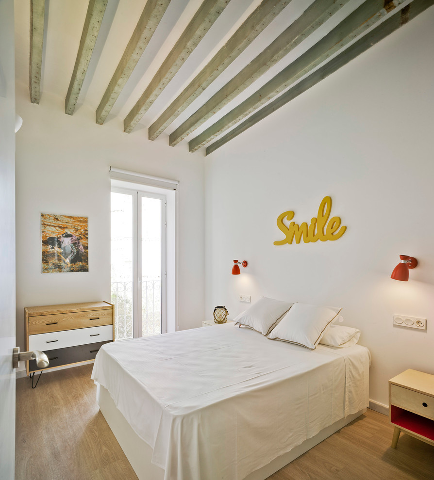 Diseño de dormitorio principal mediterráneo pequeño con paredes blancas y suelo de madera clara
