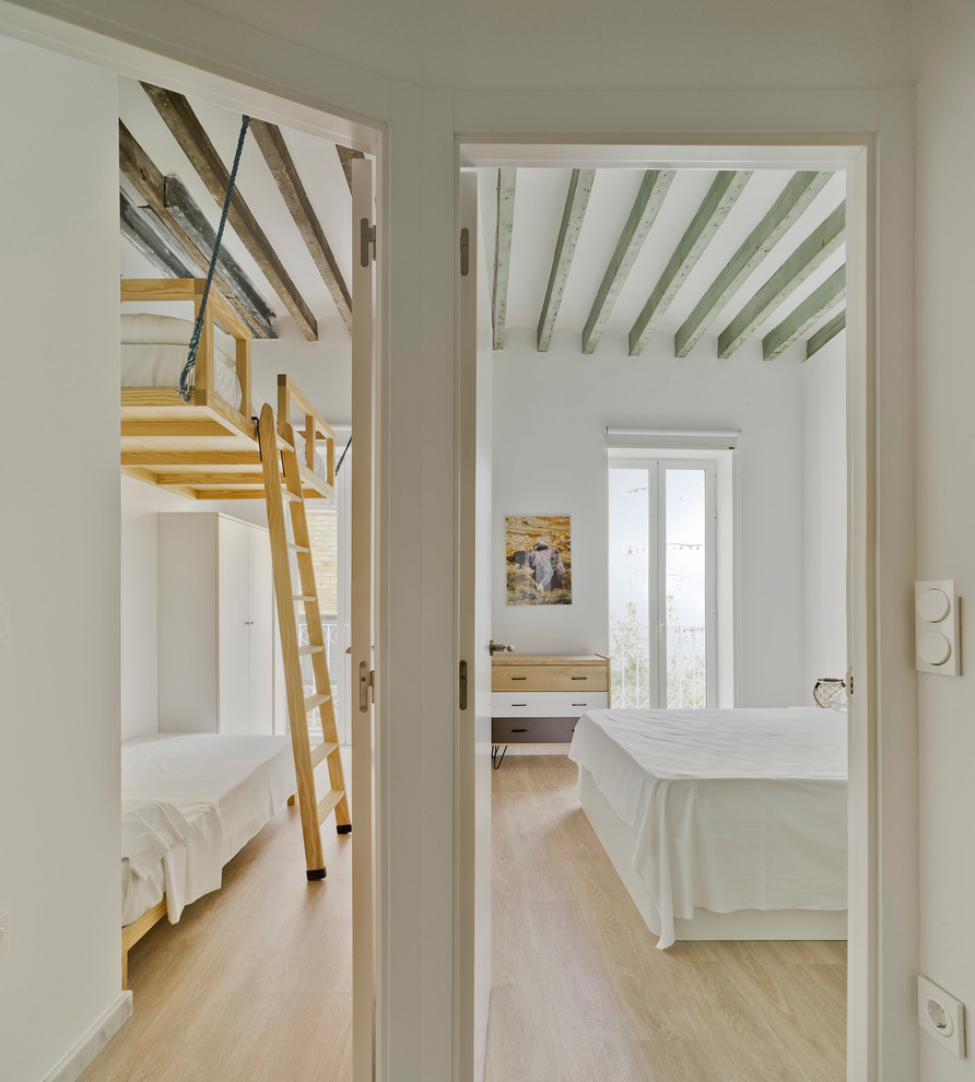 На фото: маленькая гостевая спальня (комната для гостей) в средиземноморском стиле с белыми стенами и светлым паркетным полом для на участке и в саду