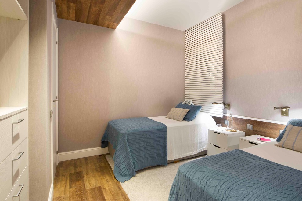 Imagen de habitación de invitados actual de tamaño medio sin chimenea con suelo de madera en tonos medios