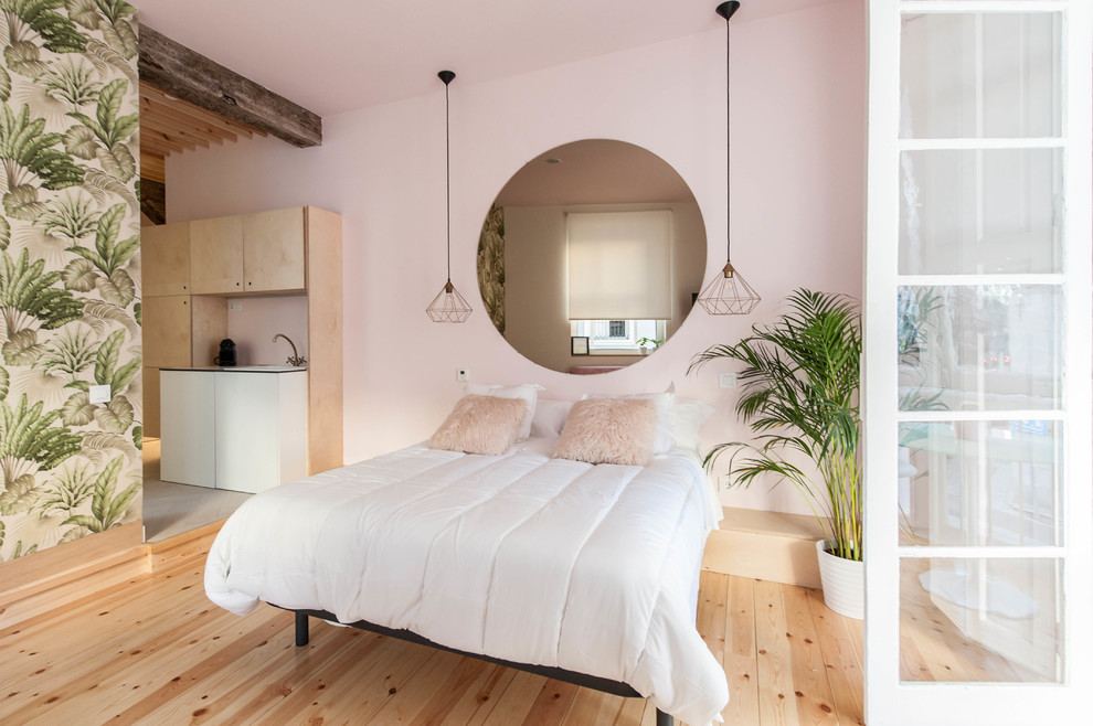 Immagine di un'ampia camera da letto tropicale con pareti rosa, parquet chiaro e pavimento marrone