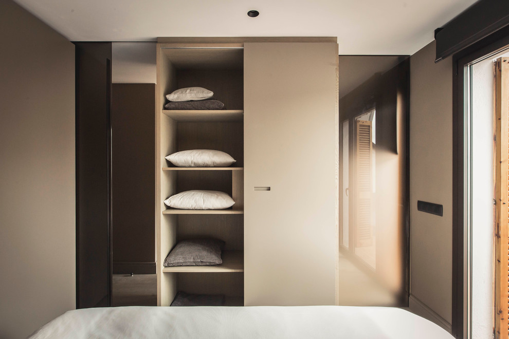 Foto de dormitorio principal actual de tamaño medio con paredes marrones y suelo de madera en tonos medios