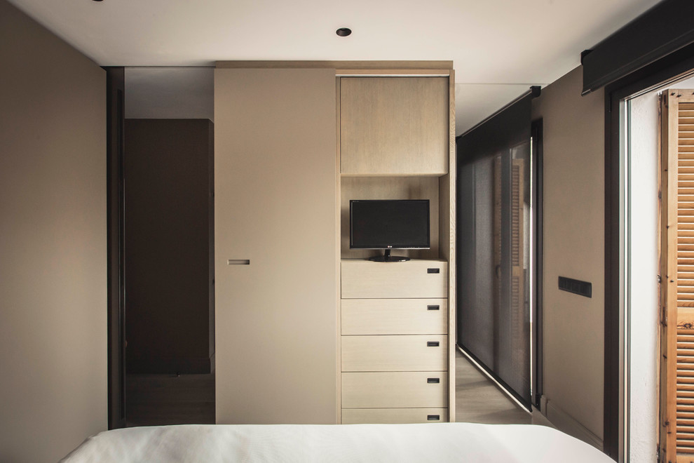 Inspiration for a medium sized contemporary master bedroom in Barcelona with brown walls and medium hardwood flooring.