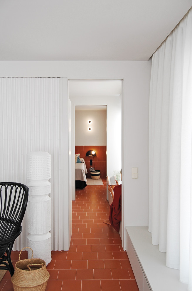 Idee per una camera matrimoniale minimalista di medie dimensioni con pareti bianche, pavimento in terracotta, nessun camino e pavimento marrone