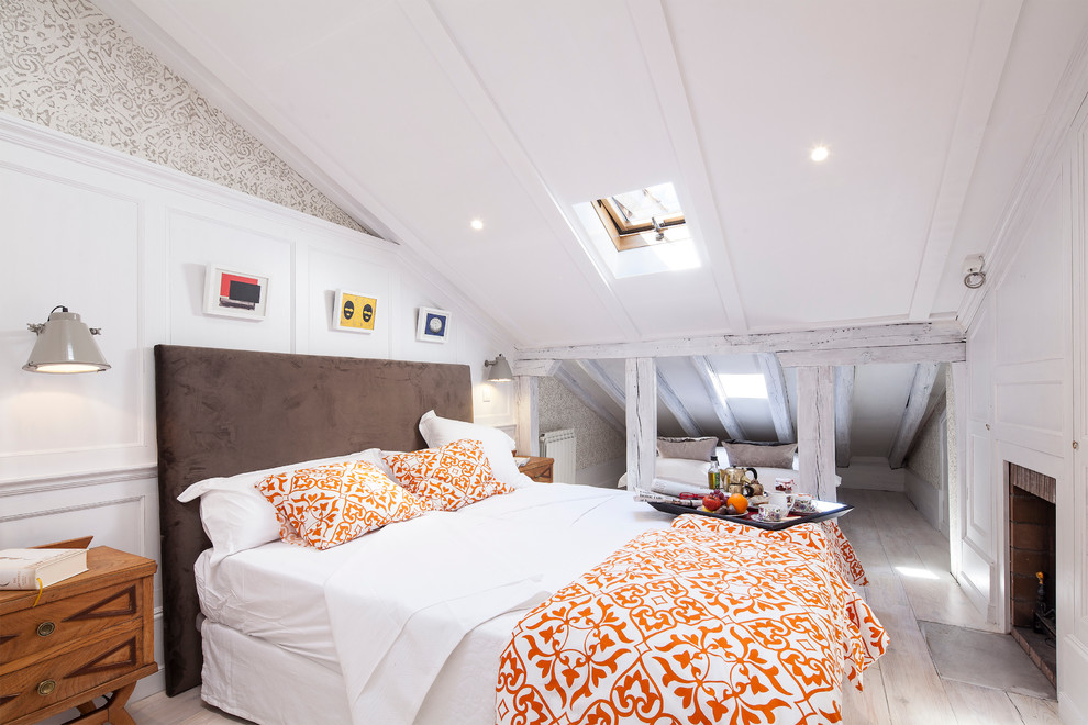 Kleines Eklektisches Hauptschlafzimmer mit weißer Wandfarbe, hellem Holzboden, Kamin und Kaminumrandung aus Backstein in Madrid